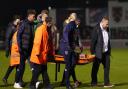 Medical staff and stewards carry Upminster man Kevin Roome away on a stretcher during the FA Cup first round match between Dagenham & Redbridge and Salford City.