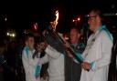 Alby pictured holding the Paralympic torch with Glynn Bentley, the assistant co-ordinator of the pupil administration and support service at Shenfield High School where Alby was a pupil.