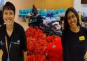 Nurses Charleen and Deepika displaying a pile of free school uniforms to give away