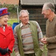 Queen Elizabeth II talks to gardening enthusiasts Donald Doody (left) and John Harrison on their allotment, in Redbridge Lane West, during her Golden Jubilee visit to east London.