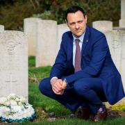 Sanders Draper headteacher Stuart Brooks at the grave of Raimund Sanders Draper at St Andrews Church, Hornchurch