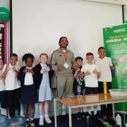 Big Manny with pupils from his former primary school, Henry Green Primary School, in Dagenham