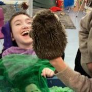A child at Lime Academy Ravensbourne laughs with joy at a puppet. The school has kept its 'good' rating after a recent Ofsted inspection