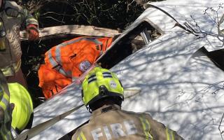 Firefighters attempt to free the man trapped in the aircraft