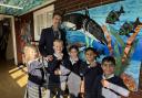 Rush Green Primary pupils showing off their watches with headteacher Simon Abeledo