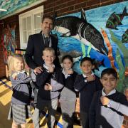 Rush Green Primary pupils showing off their watches with headteacher Simon Abeledo