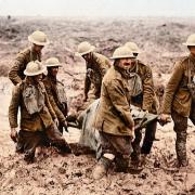 British soldiers carry a wounded comrade to safety through the mud of the First World War